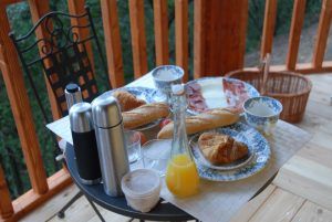 La mesa de desayuno al aire libre de la Habitación mágica en los árboles por Cabanes Dosrius (Barcelona) ofrece un entorno mágico con bollería, baguettes, jamón, queso, vasos de zumo natural y termos enclavados entre los árboles. - ForTwo - Planes para parejas