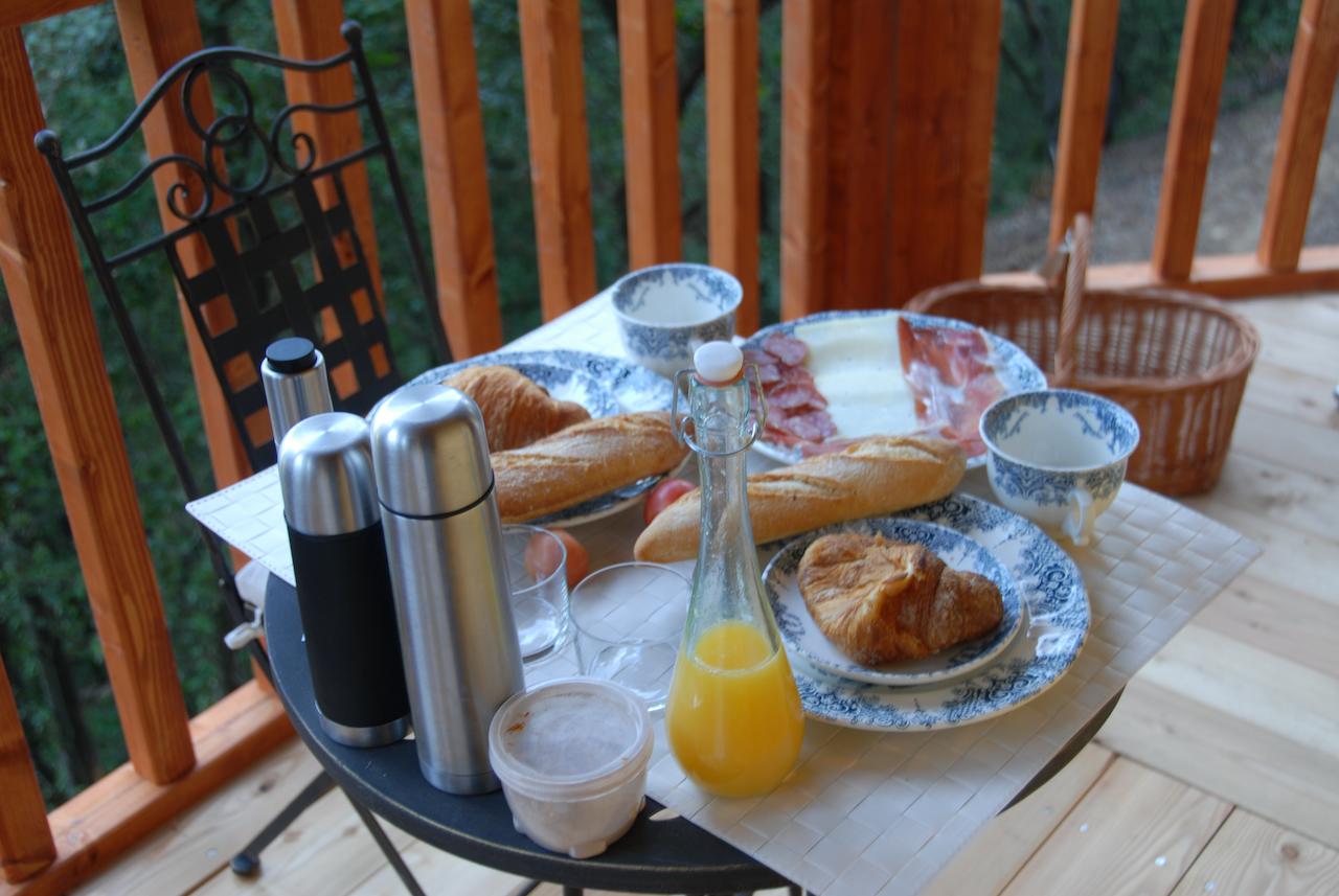 La mesa de desayuno al aire libre de la Habitación mágica en los árboles por Cabanes Dosrius (Barcelona) ofrece un entorno mágico con bollería, baguettes, jamón, queso, vasos de zumo natural y termos enclavados entre los árboles. - ForTwo - Planes para parejas
