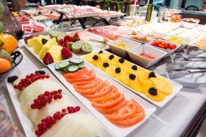 El buffet "Estancia de ensueño" del Hotel Petit Palace Bilbao ofrece una experiencia encantadora con una presentación bellamente organizada de frutas en rodajas, verduras, quesos y diversos aderezos. - ForTwo - Planes para parejas