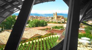 Experimente la impresionante vista de la ciudad con una iglesia y viñedos enmarcados por la moderna Bodega Marqués de Riscal en las majestuosas montañas de Álava. Explora y deléitate con una inolvidable "Visita a bodega Marqués de Riscal (Álava). - ForTwo - Planes para parejas