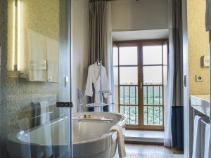 Experimente el lujo con una bañera redonda y una bata de felpa en un baño de Estancia en la Abadía Retuerta LeDomaine (Valladolid), que ofrece una vista panorámica a través de una gran ventana que lo sumerge en la serena belleza de Valladolid. - ForTwo - Planes para parejas