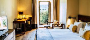 Disfrute de una estancia tranquila en la Estancia en la Abadía Retuerta LeDomaine, Valladolid, que ofrece una acogedora habitación con una cama grande, escritorio y una ventana abierta que ofrece impresionantes vistas de exuberantes paisajes verdes. - ForTwo - Planes para parejas