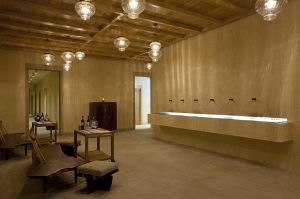 Explore la minimalista sala de catas de Estancia en la Abadía Retuerta LeDomaine (Valladolid), decorada con un techo de madera, lámparas colgantes y un amplio mostrador con grifos. Disfrute de los bancos rodeados de botellas de vino que capturan la esencia de una estancia vallisoletana. - ForTwo - Planes para parejas