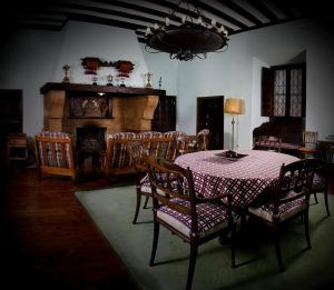 Este comedor vintage, inspirado en el encanto de La Posada de Pradorey (Burgos), luce una mesa redonda con sillas estampadas, una acogedora chimenea, una elegante lámpara de araña y una gran lámpara. - ForTwo - Planes para parejas