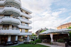 Viva una escapada romántica con el paquete "Escapada romántica al Gran Hotel Victoria con botella de cava (Santander)", que cuenta con balcones escalonados, un exuberante jardín con un encantador cenador y un exterior moderno bajo el inmenso cielo azul. - ForTwo - Planes para parejas