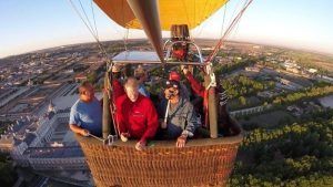 Un grupo de personas disfruta de un vuelo en globo con Eolofly en Aranjuez, sobrevolando el vibrante paisaje urbano y los exuberantes paisajes verdes. - ForTwo - Planes para parejas