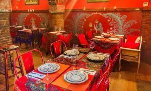 El Restaurante Noches de Moscú en Madrid luce vibrantes paredes rojas, mesas decoradas y murales decorativos. Su ambiente animado complementa a la perfección el "Menú ruso para dos", garantizando que cada visita sea una experiencia única. - ForTwo - Planes para parejas