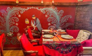 Experimente el encanto madrileño en el Restaurante Noches de Moscú, con decoración en rojo, un mural ornamentado, elegantes mesas para cuatro y cómodas sillas. El Menú ruso para dos completa su auténtica experiencia gastronómica. - ForTwo - Planes para parejas