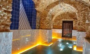 Experimente la tranquilidad con nuestro "Circuito de spa con masaje para dos" en el Hotel Pestana Plaza Mayor de Madrid. Relájese en una piscina serena con techos abovedados de ladrillo y paredes de azulejos azules, realzada por la iluminación ambiental, para un rejuvenecimiento total. - ForTwo - Planes para parejas