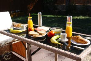 En el soleado patio de Gredos Estelar, disfrute de croissants, plátanos, sándwiches, zumo de naranja y un termo en una mesa al aire libre. Es el lugar ideal para desayunar en medio de la belleza del paisaje durante una escapada romántica en un hotel burbuja cerca de Ávila. - ForTwo - Planes para parejas