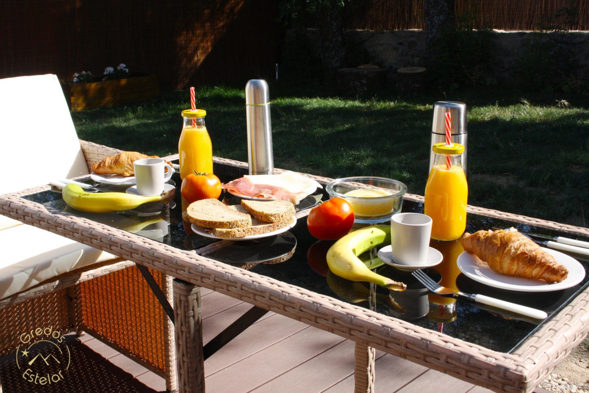 En el soleado patio de Gredos Estelar, disfrute de croissants, plátanos, sándwiches, zumo de naranja y un termo en una mesa al aire libre. Es el lugar ideal para desayunar en medio de la belleza del paisaje durante una escapada romántica en un hotel burbuja cerca de Ávila. - ForTwo - Planes para parejas