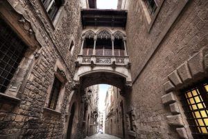 Pasea por una estrecha calle medieval de Barcelona y únete al Free tour por Barcelona para admirar el ornamentado puente de piedra que une elegantemente dos edificios históricos. - ForTwo - Planes para parejas