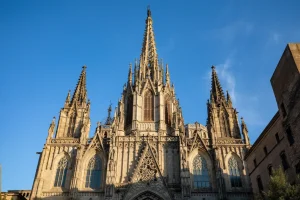 Admira la majestuosa fachada de la catedral gótica con sus intrincadas agujas y ventanas ornamentadas contra el cielo azul en un tour gratuito por Barcelona, y explora esta maravilla arquitectónica y más en el centro de la ciudad. - ForTwo - Planes para parejas