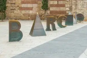 Explora la escultura de letras BARCINO, cada una de ellas de una elaboración única y expuesta en un patio histórico. Esta encantadora parada del "Free tour por la Barcelona romana" captura con belleza la esencia de la Barcelona antigua. - ForTwo - Planes para parejas