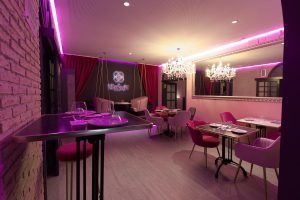 Sofisticado interior de Miss Sushi Granada con iluminación rosa, mesas elegantes, candelabros y un letrero de neón. - ForTwo - Planes para parejas