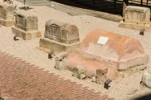 Descubra los antiguos sarcófagos de piedra de la Barcelona Romana, expuestos al aire libre sobre grava con placas informativas y pasarelas de ladrillo. Participe en un "Tour gratuito por la Barcelona Romana" para explorar la fascinante historia que esconden estas reliquias. - ForTwo - Planes para parejas