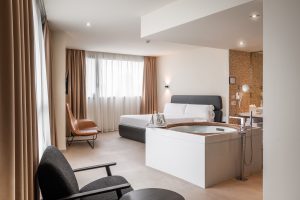Descubre la tranquilidad del Hotel con jacuzzi SB Diagonal Zero en Barcelona, que dispone de una habitación con cama, sillón, gran ventanal y bañera exenta para la máxima relajación después de tu aventura en la ciudad. - ForTwo - Planes para parejas