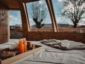 Una acogedora bandeja de desayuno con zumo, pan y cruasanes sobre una cómoda cama es el comienzo perfecto de un día en Iglús panorámicos en plena Selva de Irati (Navarra), con su frondoso bosque y sus lejanas vistas a las montañas: una experiencia verdaderamente maravillosa. - ForTwo - Planes para parejas