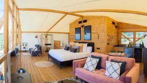 Experimente el lujo en una tienda glamping estilo cordobés con interior de madera, cama doble, sofá rosa y cocineta. Disfrute de dos noches en La Dehesa Experiences con vistas impresionantes, perfectas para una velada tranquila o una cena romántica bajo las estrellas. El paquete incluye cena y desayuno. - ForTwo - Planes para parejas