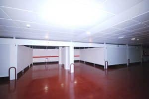 El Hotel Los Peñascales de Madrid cuenta con un elegante aparcamiento subterráneo con suelo rojo brillante y paredes blancas, garantizando tanto elegancia como máxima privacidad. - ForTwo - Planes para parejas
