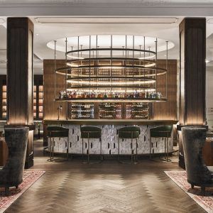 Disfrute de un cóctel elaborado a la perfección en el elegante bar del Gran Hotel Inglés, con lujosos taburetes verdes, una encimera de mármol adornada con botellas y elegantes lámparas colgantes. Experimente el ambiente sofisticado con acceso al jacuzzi y un paquete de masajes. - ForTwo - Planes para parejas