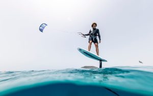 Disfruta del kitesurf sobre el agua en una tabla de hidroala con una cometa surcando el cielo despejado de Tarifa durante el Curso de KiteSurf para dos personas de Subcielo KiteSchool Tarifa (Cádiz). - ForTwo - Planes para parejas