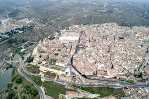 Experimente una vista aérea de Toledo, una ciudad histórica con densos edificios, calles sinuosas y un río abrazado por verdes colinas, desde la perspectiva incomparable de un "Vuelo en globo en Toledo". - ForTwo - Planes para parejas