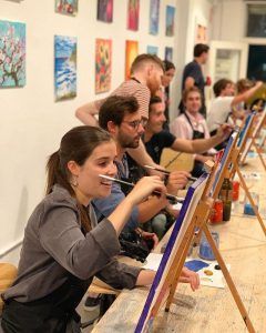 En una vibrante Clase de pintura con tu copita de vino en Arte Bar (Barcelona), los participantes pintan sobre lienzos en medio de coloridas pinturas y animadas obras de arte. - ForTwo - Planes para parejas