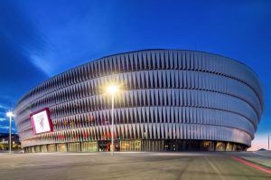 Descubra la maravilla moderna del Estadio San Mamés en un "Tour por el estadio San Mamés (Bilbao)". Este estadio circular cuenta con distintivas lamas verticales y una fachada que se ilumina con belleza al anochecer, convirtiéndolo en un punto de interés vibrante para cualquier visita a la ciudad. - ForTwo - Planes para parejas
