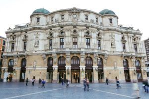 El histórico teatro de piedra de Bilbao cuenta con techos abovedados, ventanas arqueadas y esculturas intrincadas. Los visitantes pueden descubrir este hito cultural con el "Tour gratuito por Bilbao", mientras la gente pasea y se sumerge en su rica atmósfera. - ForTwo - Planes para parejas