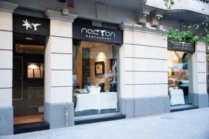 El restaurante Nectari de Barcelona luce su Estrella Michelin con dos grandes ventanales y una elegante señalización encima de cada uno de ellos. - ForTwo - Planes para parejas