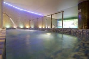 Disfrute del lujo del oasis interior de Granada Palace & Spa, con su cascada, mosaicos y relajantes luces LED moradas. Mejore su visita con un circuito termal y masaje con piedras calientes en medio de un tranquilo mural natural. - ForTwo - Planes para parejas