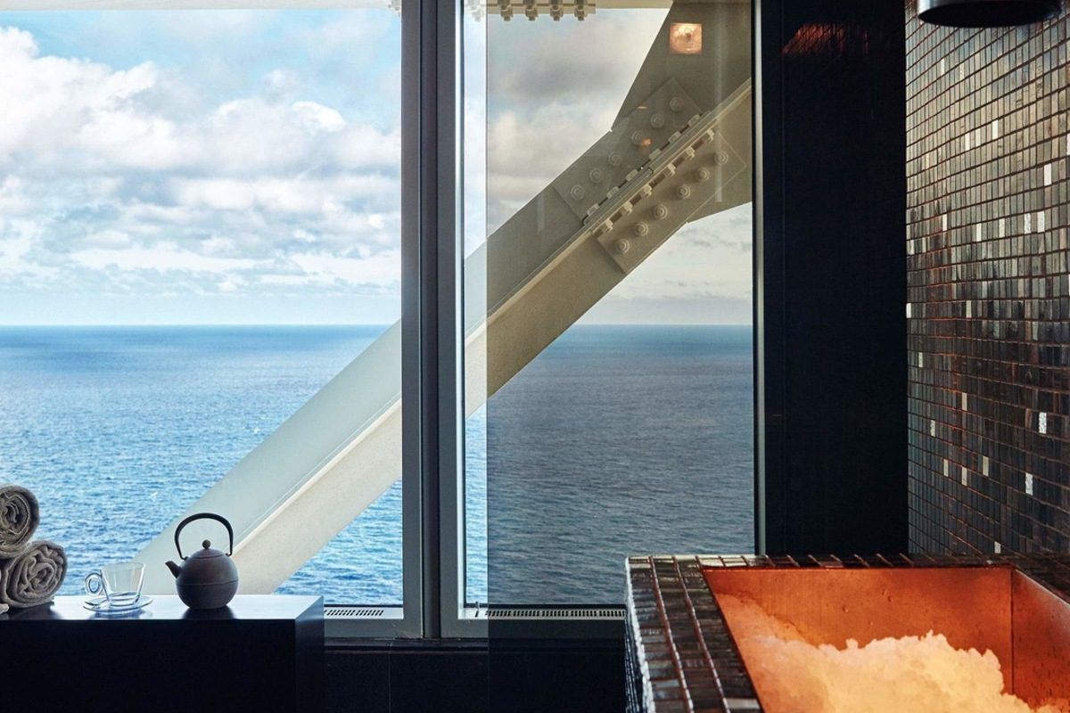Experimente la vista al mar desde una bañera en el Spa de Lujo en el Hotel Arts, Barcelona, con una tetera cerca para una relajación serena. Disfrute del Desayuno, Spa de Lujo y Masaje: La Experiencia Total en el Hotel Arts. - ForTwo - Planes para parejas