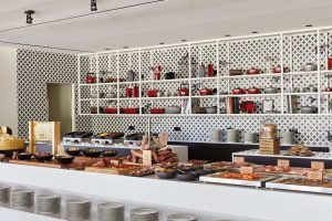 Disfrute de un delicioso desayuno en una cocina moderna con paredes estampadas, que ofrece un elegante buffet de carnes, quesos y condimentos, infundiendo su rutina matutina con la sofisticación de "Desayuno, Spa de Lujo y Masaje: La Experiencia Total en el Hotel Arts (Barcelona). - ForTwo - Planes para parejas