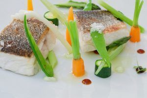 Saborea un filete de pescado gourmet con piel crujiente, rodeado de zanahorias baby, espárragos, calabacines y cebolletas en Brunch de Lujo en el hotel InterContinental de Madrid. - ForTwo - Planes para parejas