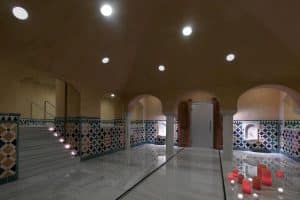 Experimente el Sumérgete en un circuito Acuático para Parejas de 60 minutos en Macià Real De La Alhambra, con mosaicos, velas, puertas arqueadas y pisos de mármol que reflejan cálidas luces en el techo para una relajación tranquila. - ForTwo - Planes para parejas