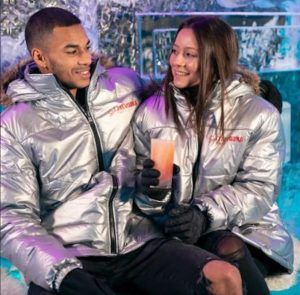 Una pareja con parkas plateadas disfruta de unas bebidas con el Pack Romántico en ICEBARCELONA, un local romántico con temática de hielo que encarna un paraíso invernal. - ForTwo - Planes para parejas