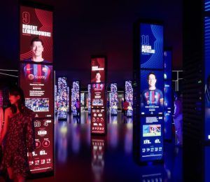 Experimenta la inmersión en el Museo del Barça: Tour Inmersivo con paneles interactivos que muestran a los jugadores de fútbol en una sala oscura, realzados por luces de colores y estadísticas digitales. - ForTwo - Planes para parejas