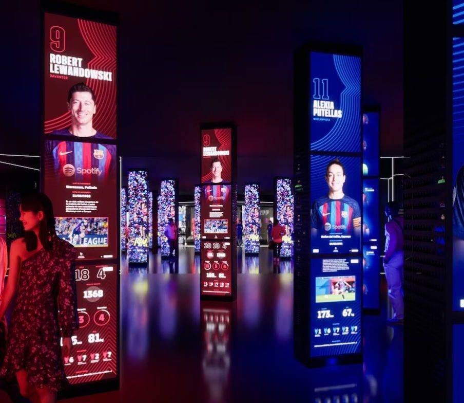 Experimenta la inmersión en el Museo del Barça: Tour Inmersivo con paneles interactivos que muestran a los jugadores de fútbol en una sala oscura, realzados por luces de colores y estadísticas digitales. - ForTwo - Planes para parejas