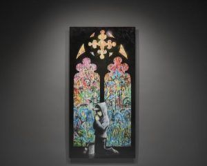 Una impactante obra de arte callejero que recuerda a Banksy presenta a una persona arrodillada ante una vibrante vidriera repleta de grafitis. Esta escena evoca las exposiciones del Museo Moco de Barcelona: Banksy y más: Sin colas. - ForTwo - Planes para parejas