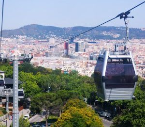 Las Entradas del Teleférico de Barcelona ofrecen impresionantes vistas de la ciudad, deslizándose sobre árboles verdes y montañas como un impresionante telón de fondo. - ForTwo - Planes para parejas