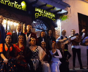 Vibrantes artistas de flamenco con atuendos coloridos posan elegantemente afuera del icónico recinto del Espectáculo Flamenco en las Cuevas del Sacromonte con Los Tarantos; su animada presencia se hace eco de la energía dinámica del lugar. - ForTwo - Planes para parejas