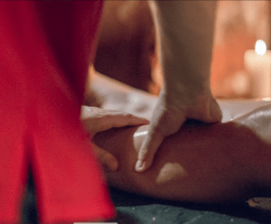 Bajo la luz de las velas, una persona disfruta de un masaje relajante que crea el ambiente de la Experiencia Hammam Tradicional - Baño Turco en Madrid, capturando el encanto de Madrid. - ForTwo - Planes para parejas