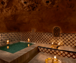 Sumérgete en el lujo de un spa inspirado en el Hammam Al Ándalus Granada, con una pequeña piscina, paredes de azulejos ornamentados y luz de velas. Disfruta de un masaje exclusivo con "Entradas para Hammam Al Ándalus Granada con masaje exclusivo" para una relajación y tranquilidad inigualables. - ForTwo - Planes para parejas