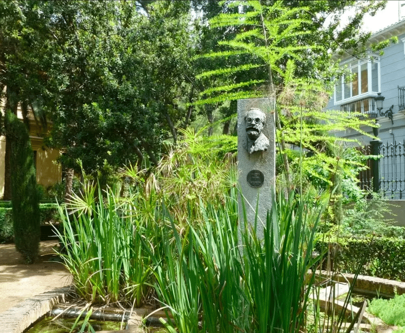 Explora el busto sobre un pedestal en medio de una exuberante vegetación, que recuerda los paisajes de Lorca, durante "Federico García Lorca: Tour guiado por Granada", una parada ideal en esta visita guiada. - ForTwo - Planes para parejas