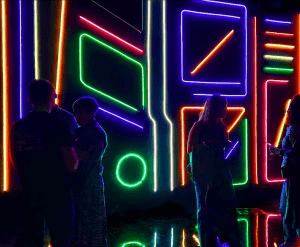 En Nomad Museo Inmersivo, luces de neón vibrantes con diseños abstractos iluminan un fondo oscuro, creando una experiencia inmersiva inolvidable para quienes acceden a él con Entradas al Nomad Museo Inmersivo. - ForTwo - Planes para parejas