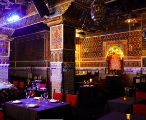 Con sus azulejos vibrantes y su decoración en rojo y azul, el interior del restaurante refleja un tablao flamenco y encarna la elegancia de Torres Bermejas, creando un brillo íntimo sobre mesas adornadas con copas de vino. - ForTwo - Planes para parejas