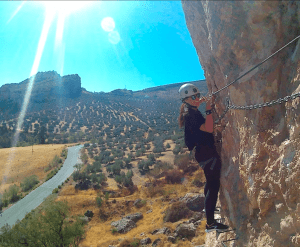 Con el equipo de seguridad puesto, el escalador escala rocas iluminadas por el sol para disfrutar de impresionantes vistas del paisaje y la carretera de abajo, experimentando una emoción tan estimulante como las "Entradas para Vía Ferrata de Moclín: Visita guiada desde Granada", donde las alturas se encuentran con la historia. - ForTwo - Planes para parejas