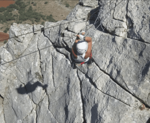 Subiendo una superficie rocosa y escarpada con casco y arnés asegurados, cuerdas que garantizan la seguridad, uno experimenta la emoción de la aventura de la Vía Ferrata de Moclín cerca de Granada. - ForTwo - Planes para parejas
