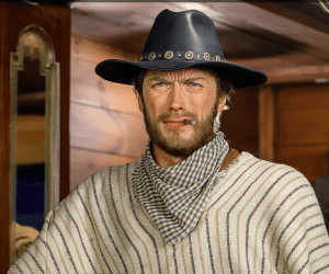 En el centro de Madrid, un hombre con atuendo vaquero, sombrero y poncho, permanece de pie en un interior con aire serio y un puro en la mano: una escena que evoca el lejano oeste, capturada a la perfección en el Museo de Cera de Madrid. No te lo pierdas; consigue ya tus Entradas al Museo de Cera de Madrid. - ForTwo - Planes para parejas